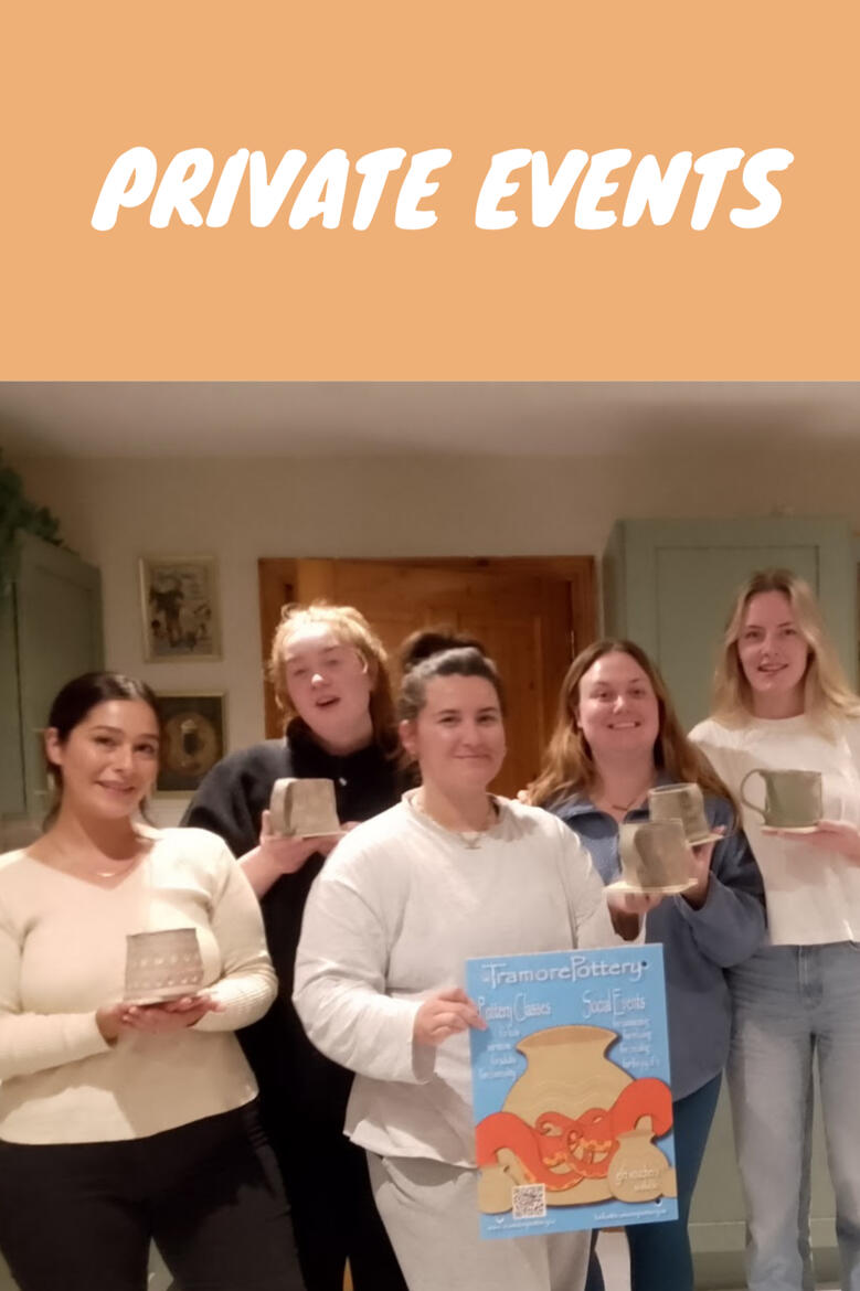 five women smile while showing the mugs they made during a private pottery workshop